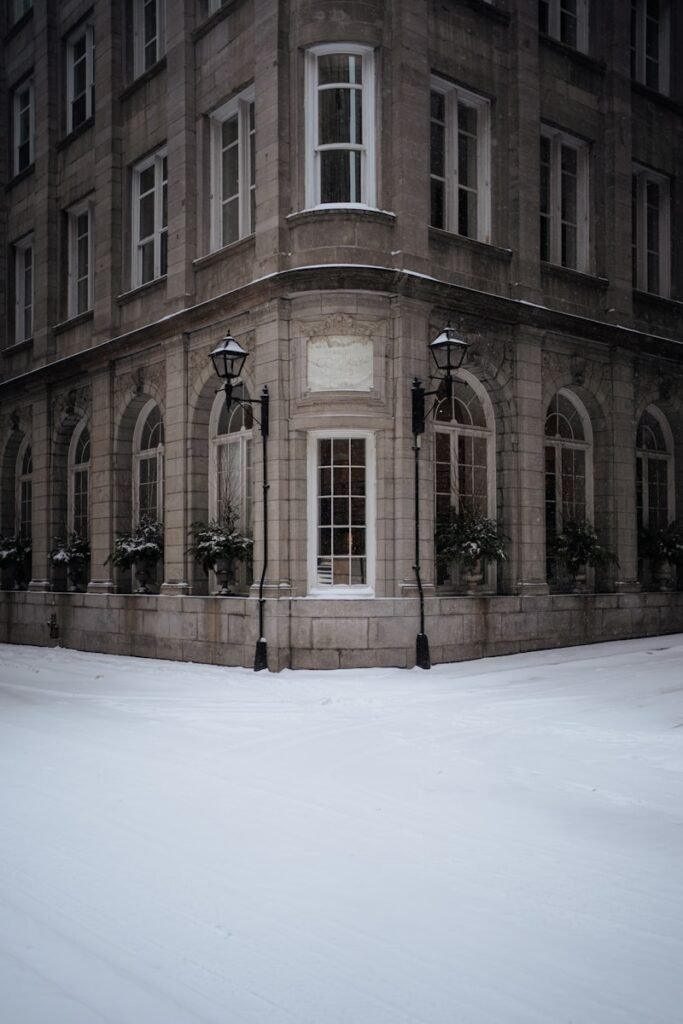 Elegant building corner with snow falling